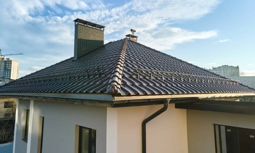 closeup-of-house-roof-top-covered-with-ceramic-shingles-with-gutter-pipes.jpg